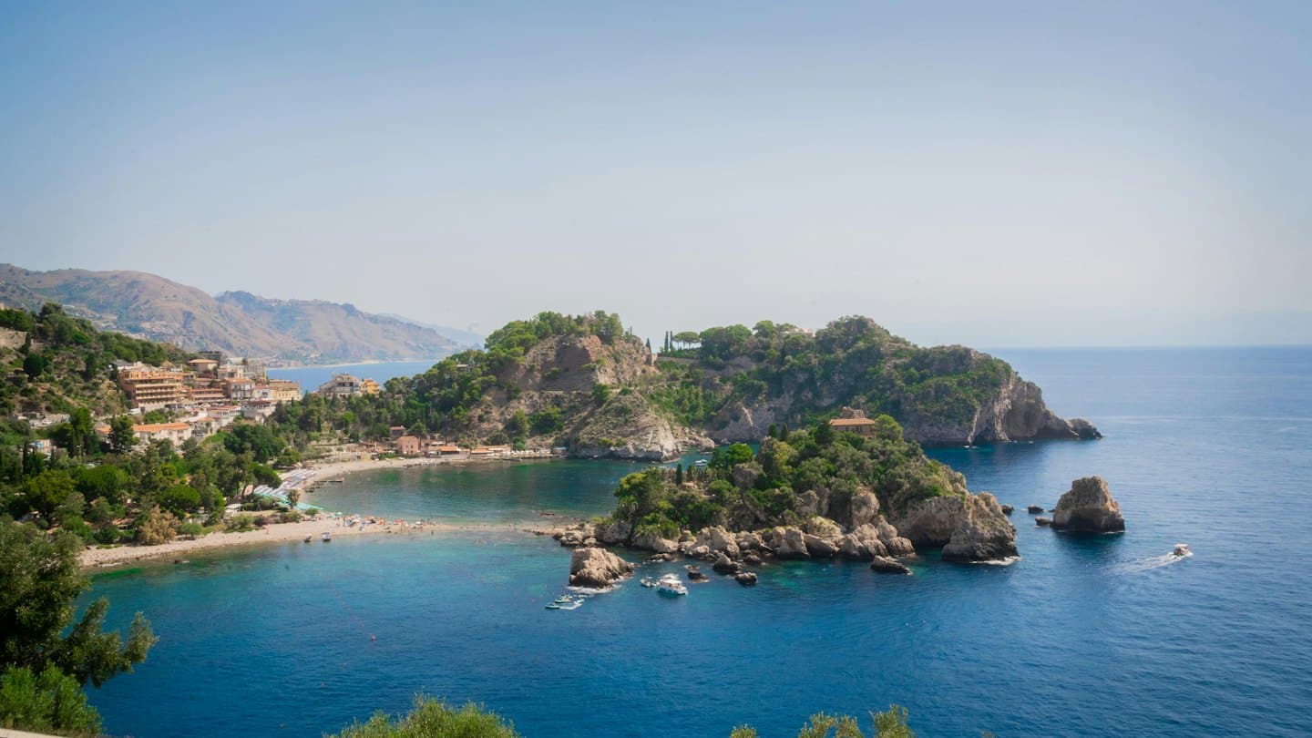 Un paese mediterraneo adagiato sulle colline che si affacciano su una baia costiera.